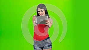 Green screen. Selfie photo brunette using front camera of tablet