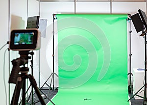 Green screen studio background. Filming or photography studio set with lights and filming equipment