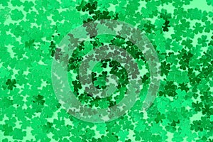 Green shamrock confetti on green as a St. Patrick’s Day background