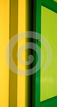 Green shutter on yellow wall
