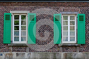 Green shutters, deluxe white concrete sash and frieze, and small balcony.