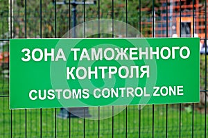 Green sign with the inscription in Russian and English: Customs control zone
