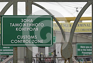 Green sign with the inscription in Russian and English `Customs control zone`