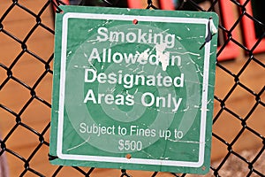 A Green Sign at a Playground that Reads