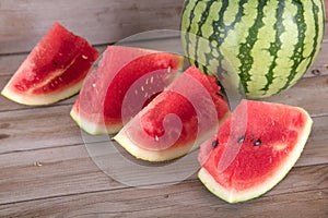 A green-skin watermelon and a few sliced watermelons