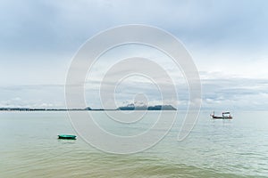 Green small fishng boat parked at the shore of Prachuap Bay with