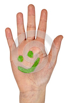 Green smiling face drawn on child palm