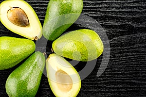 Fresh raw smooth avocado on black wood photo