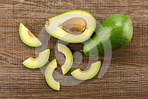 Fresh raw smooth avocado on brown wood photo