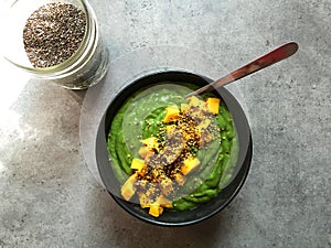 Green smoothie bowl with chopped mango and chia seeds