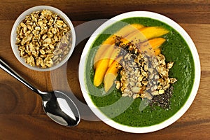 Green smoothie bowl with mangoes, granola and chia seeds