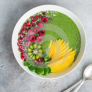 green smoothie bowl with spinach, mango, kiwi and raspberry. Healthy vegan raw food