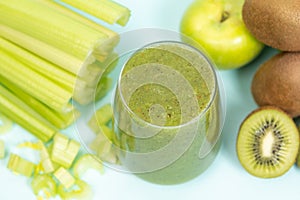 Green smoothie of celery, kiwi, green apple and spinach in a glass