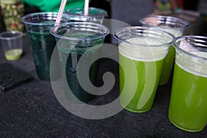 Green smoothie cocktail with spirulina, chlorella and alga on wooden background. Healthy veggy summer detox food.