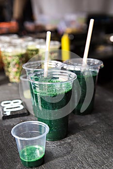 Green smoothie cocktail with spirulina, chlorella and alga on wooden background. Healthy veggy summer detox food.