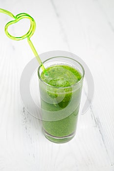 Green smoothie in a glass with a straw. Healthy concept
