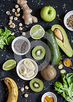 Green smoothie ingredients. Cooking healthy detox smoothies. On a dark background