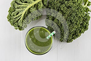 Green smoothie with kale leaves and straw