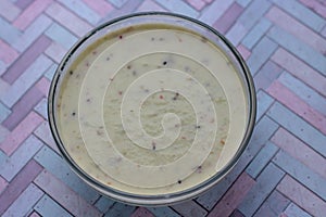 Green smoothie with kiwi fruit, cucumber, mint and parsley on old grey wooden desk