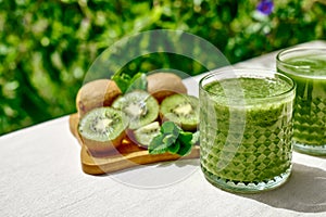 Green smoothie with kiwi fruit in the glasses. Healthy organic drink. Nutrition and alkaline diet. Healthie eating vegetarian