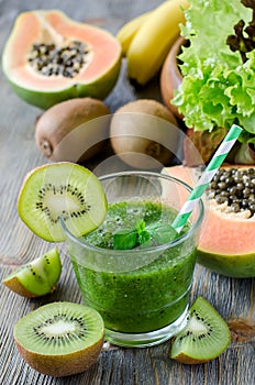 Green smoothie with kiwi, papaya, bananas and salad leaves