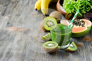 Green smoothie with kiwi, papaya and salad leaves copy space