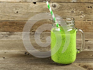Green smoothie on old wood background