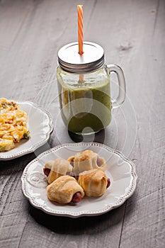 Green smoothie with pigs 'n blankets