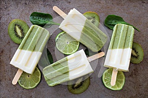 Green smoothie popsicles on a rustic metallic background