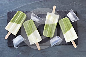Green smoothie popsicles on a slate background