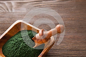 Green smoothie with spirulina on wood background