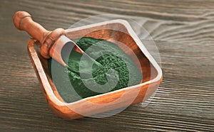 Green smoothie with spirulina on wood background