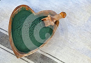 Green smoothie with spirulina on wood background