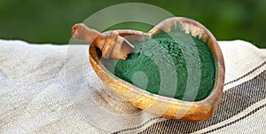 Green smoothie with spirulina on wood background