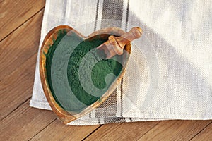 Green smoothie with spirulina on wood background