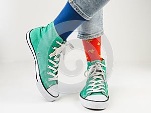 Green sneakers and funny socks on a white background