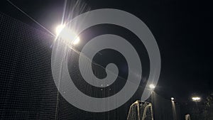 Green soccer field row of bright spotlights illuminated stadium in night