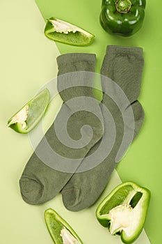 Green socks and bell pepper on two tone background
