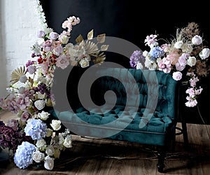 green sofa decorated with flowers in a photo studio