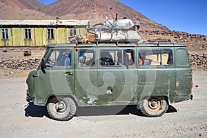 Green Soviet old van loaded with bicycle in Pamir mountains