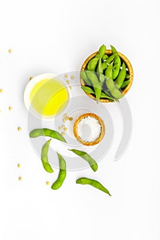 Green soybeans or edamame and oil for fresh healthy food on white background top view