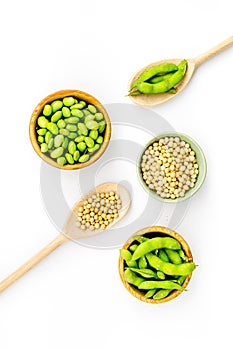 Green soybeans or edamame in spoon and bowl for fresh healthy food on white background top view