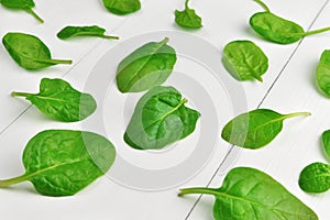 Green spinach leaves on white wooden background. Vegan food lifestyle concept