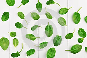 Green spinach leaves on white wooden table background. Healthy vegan food trend. Eco-conscious concept. Top view