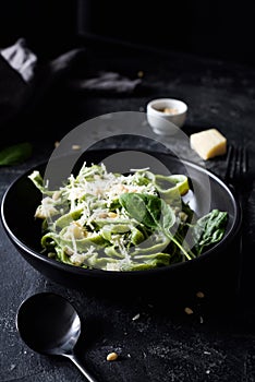 Green spinach pasta with cheese and pine nuts