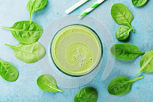 Green spinach smoothie on blue table top view. Detox and diet food for breakfast.