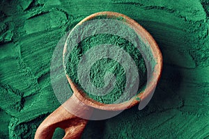 Green spirulina algae powder on a spoon