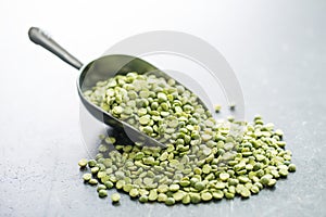 Green split peas in metal scoop.