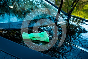 Green sponge over the car for washing. Car washing outdoor. Cleaning concept.Transportation self service, care concept