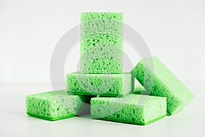 Green sponges for cleaning on a white background